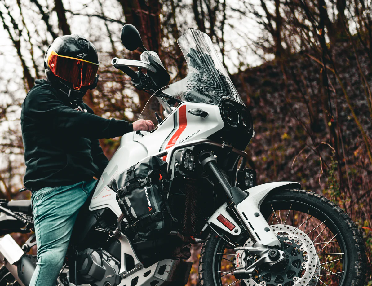 DDXMoto adjusting a Ducati DesertX in a forest