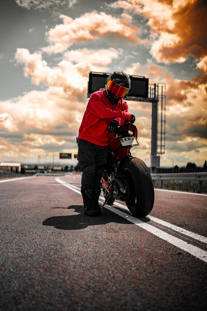DDXMoto with a red Ducati Panigale on an open road beneath dramatic clouds