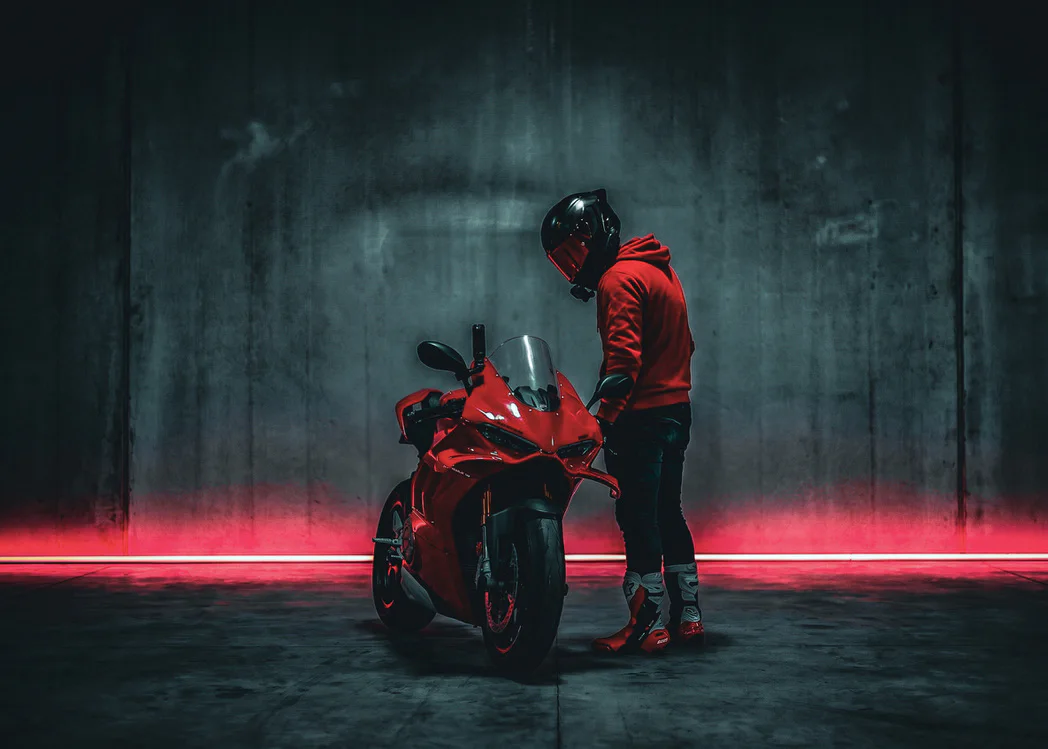 DDXMoto beside a red Ducati Panigale in a studio crossed by red light
